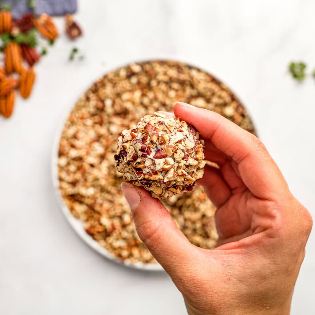 Mini Cheese Ball recipe held in fingers.