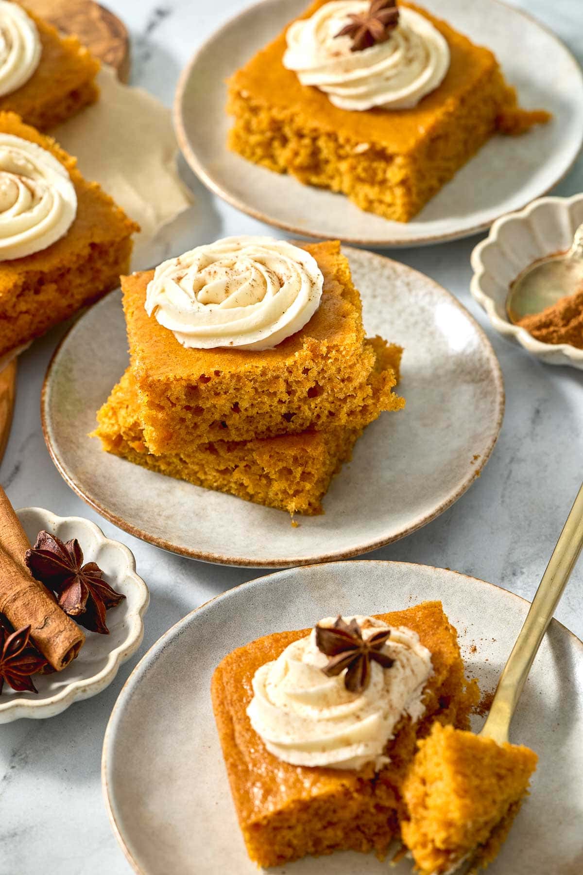 Pumpkin Bars with Cream Cheese Frosting on plates with rosettes of frosting.