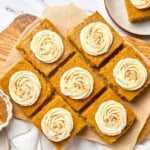Pumpkin Bars with Cream Cheese Frosting on parchment paper aerial view.