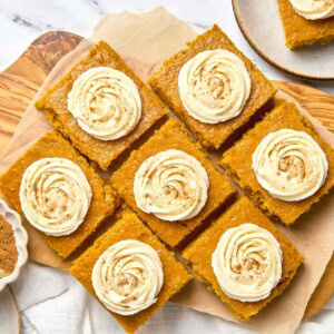 Pumpkin Bars with Cream Cheese Frosting on parchment paper aerial view.
