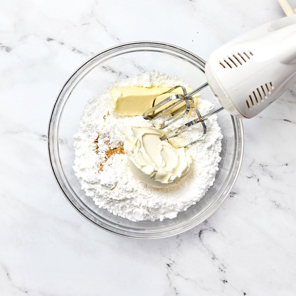 Cream cheese frosting ingredients in bowl.