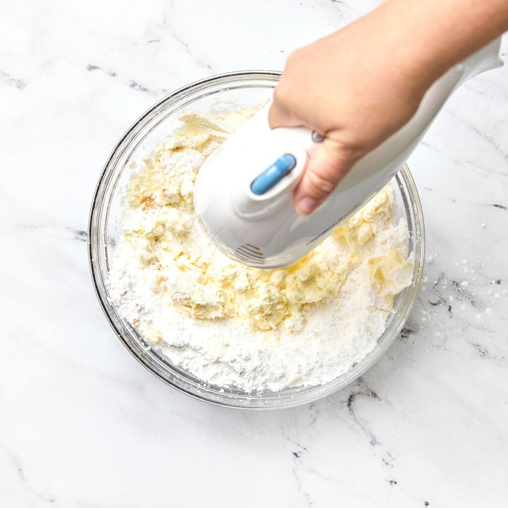 Blending powdered sugar into other ingredients.