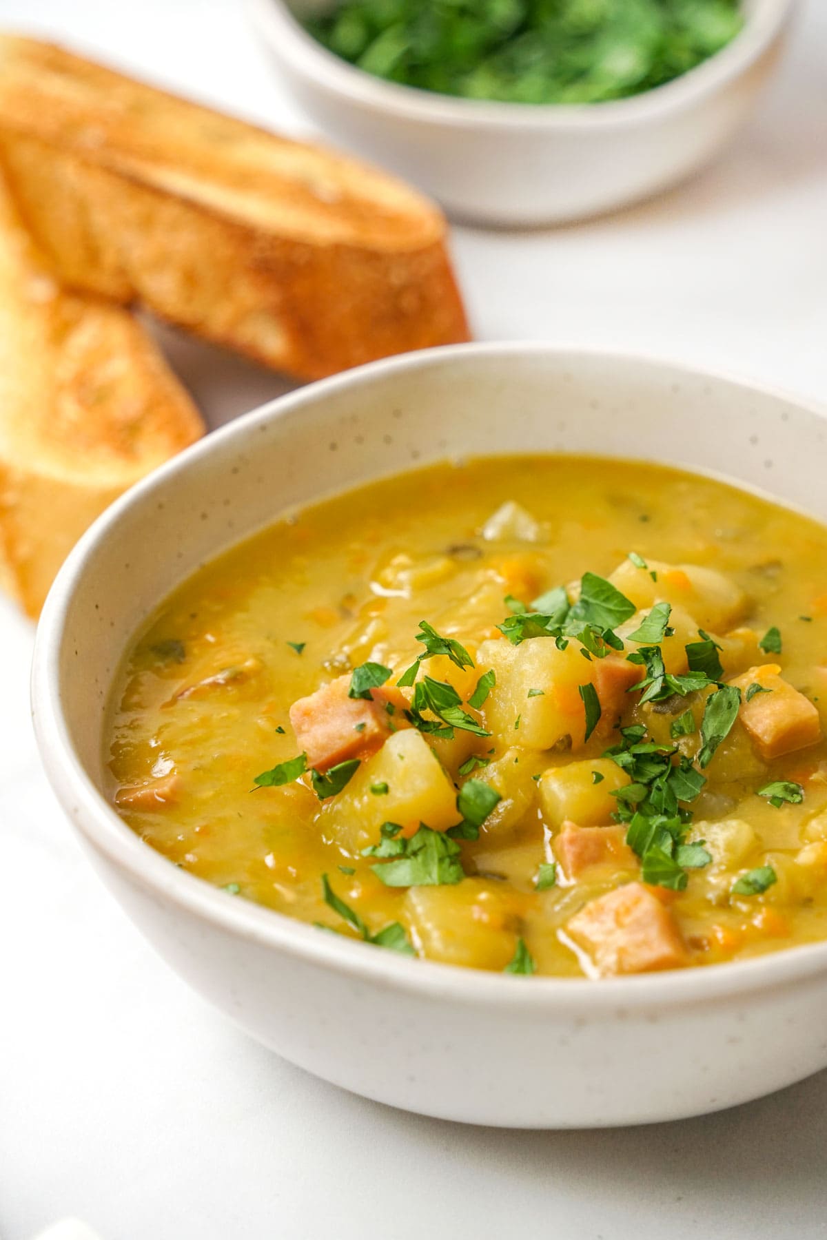 Slow Cooker Split Pea Soup with ham and parsley garnish.