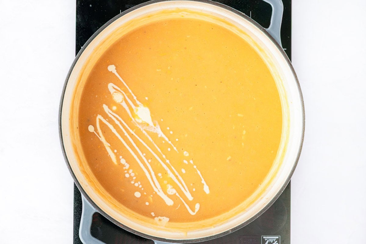 Adding half and half to Cheesy Potato Soup recipe.