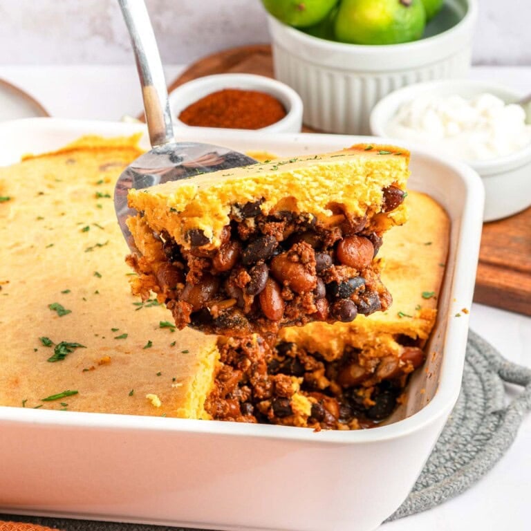 Chili Cornbread Casserole lifted from baking dish by metal spatula.
