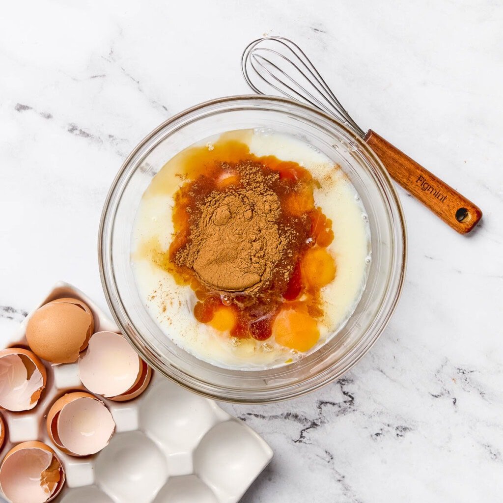 Eggs, milk, vanilla, and cinnamon in bowl.