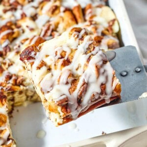 Cinnamon Roll Casserole held over dish.