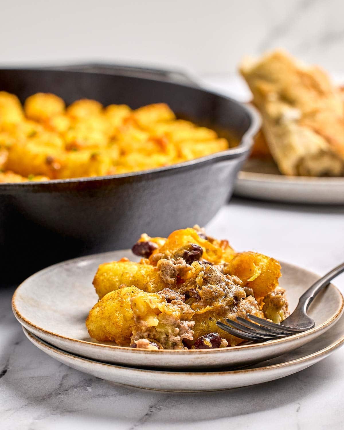 Cowboy Casserole on plate with fork and skillet in background.