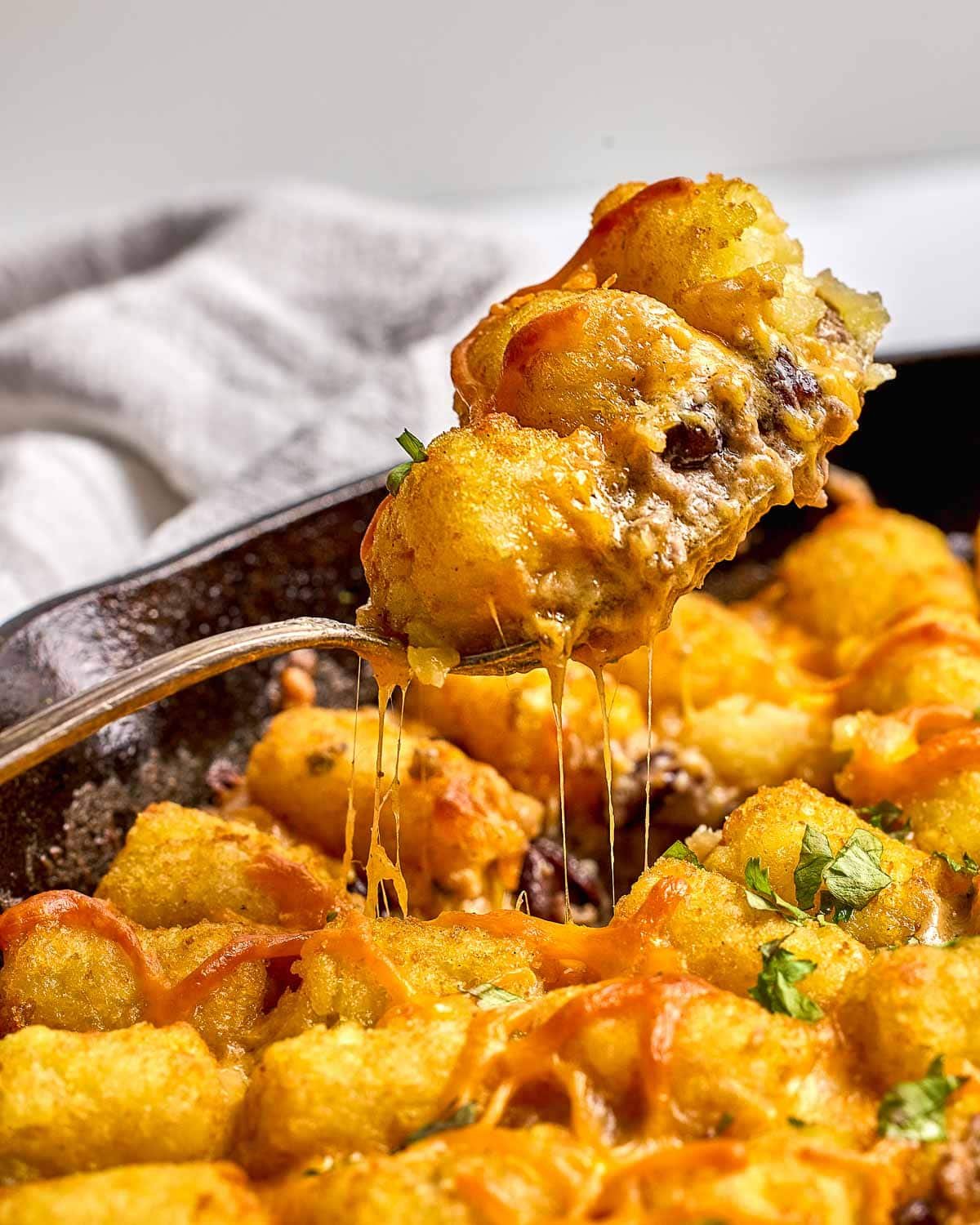 Cowboy Casserole serving lifted over skillet.