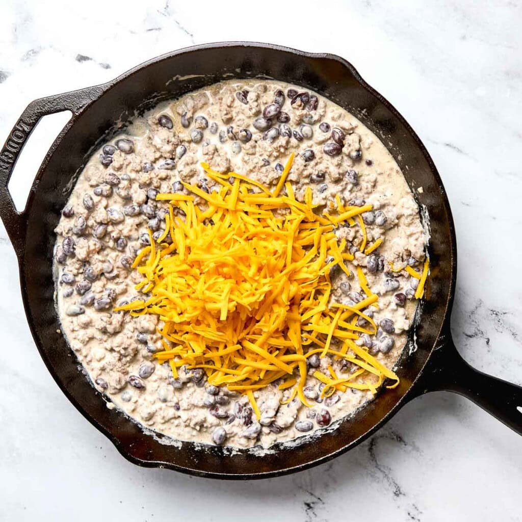 Adding cheddar to pan.