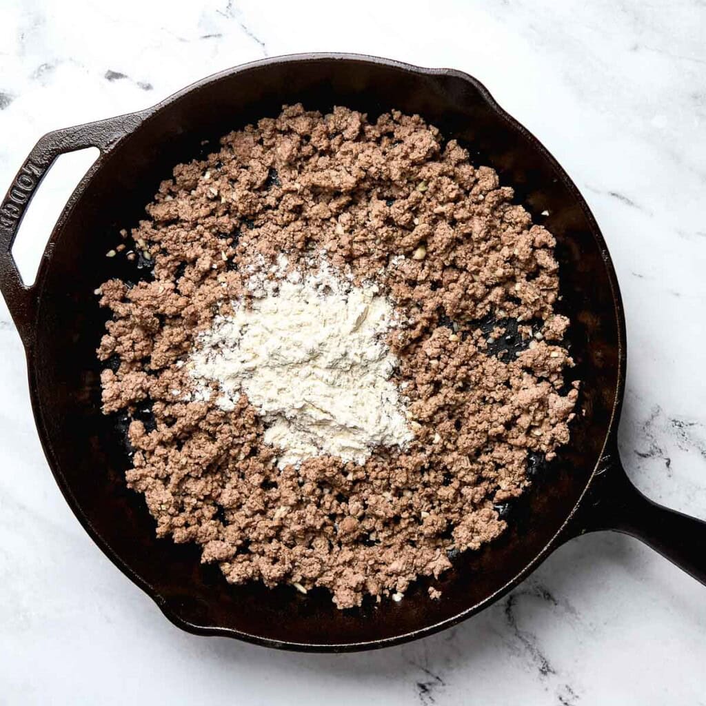 Flour sprinkled over cooked ground beef.