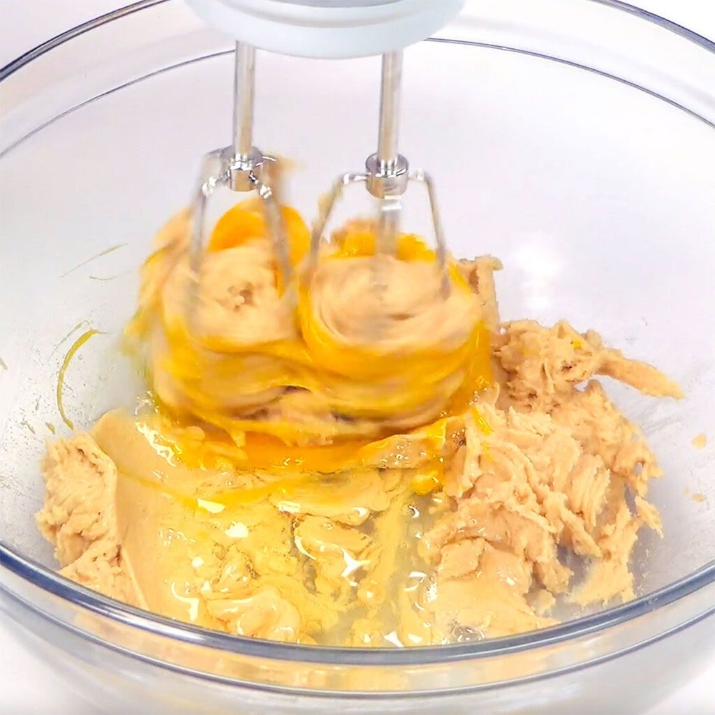 Beating egg into dough.